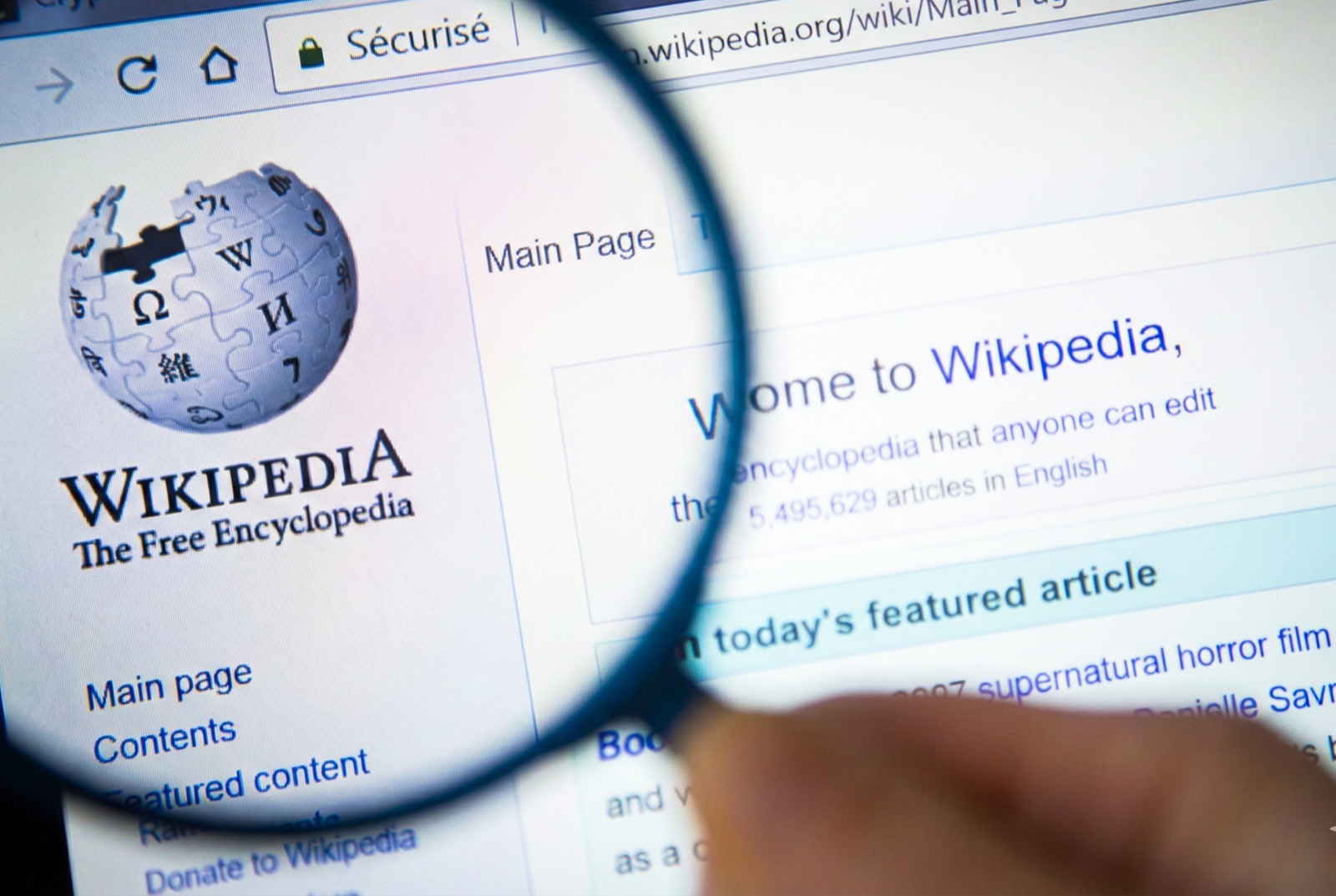 Wikipedia page under magnifier representing compliance-focused page creation